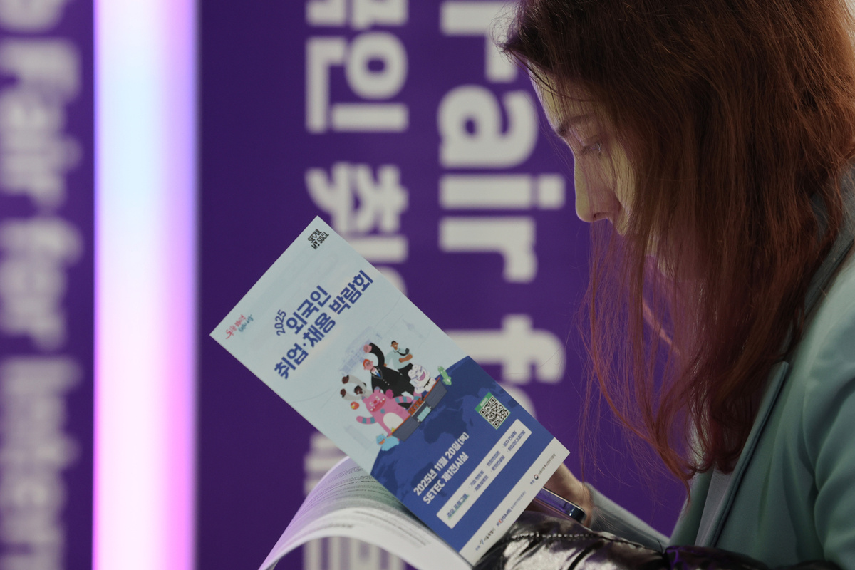 Соискатель работы просматривает брошюру 20 декабря во время ярмарки вакансий для иностранцев в округе Каннам-гу, Сеул (Ренхап)