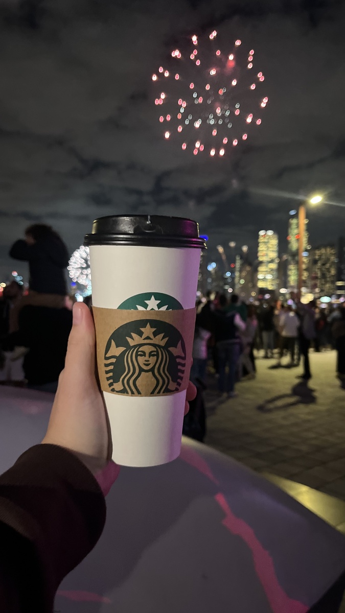 Стаканчик старбакса на фоне салюта