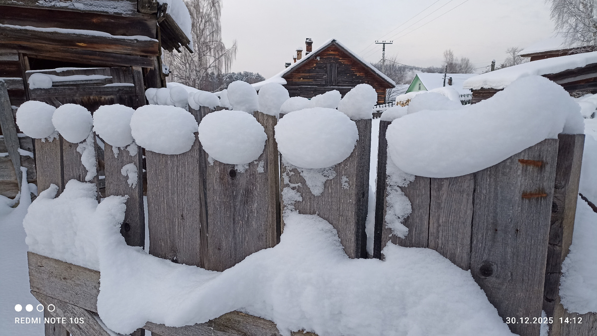 Снег создал на заборе причудливые узоры. Фото автора.