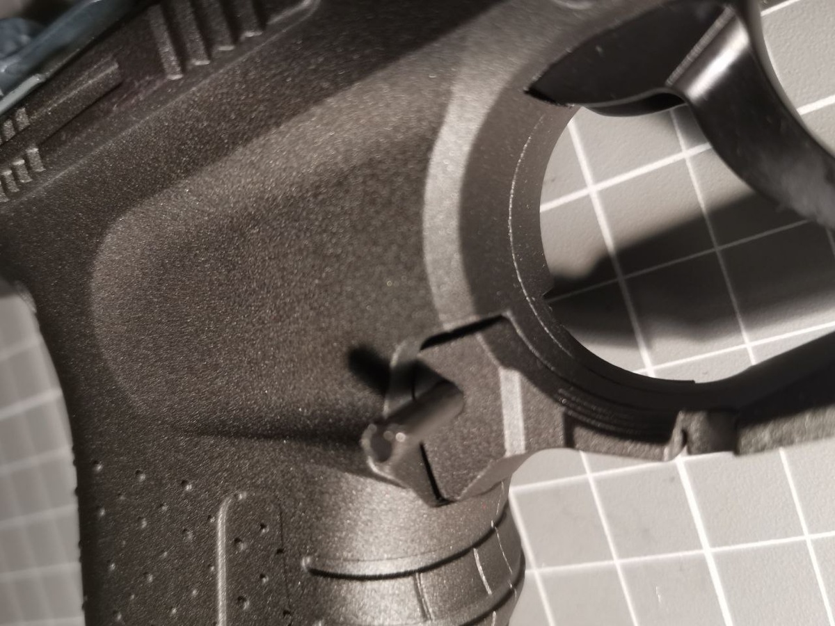 Выбиваем на правую сторону штифт из рычага сброса магазина и снимаем рычаг