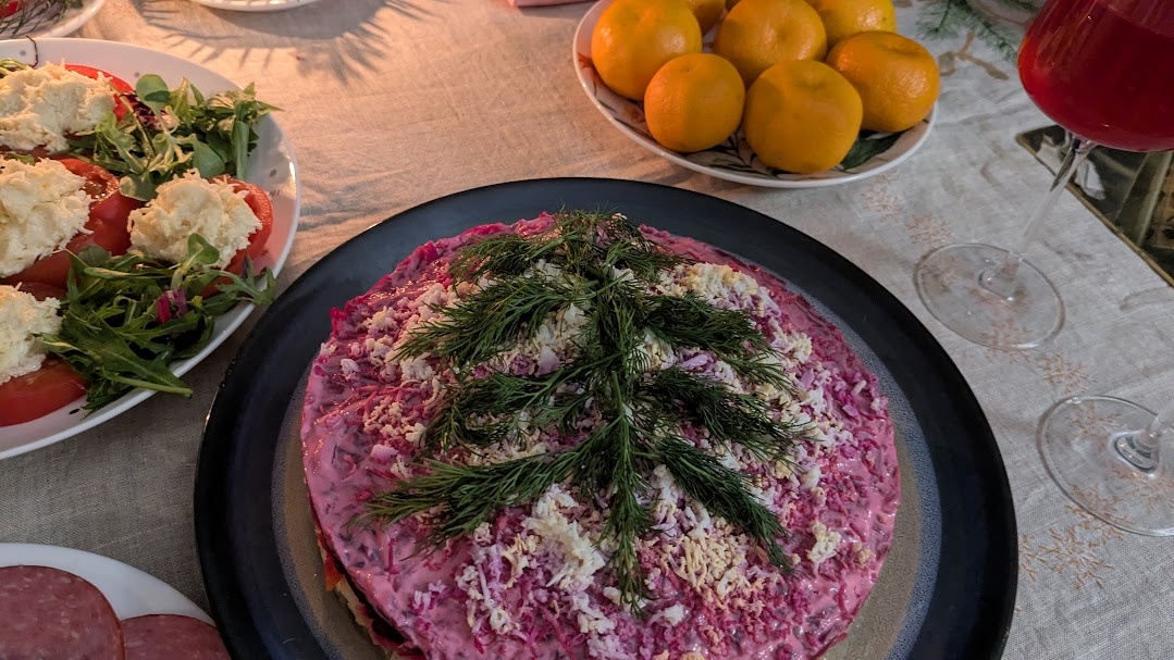 Фрагмент праздничного стола. Селедку под шубой собрала в кольце и украсила укропом в виде елочки. Фото автора