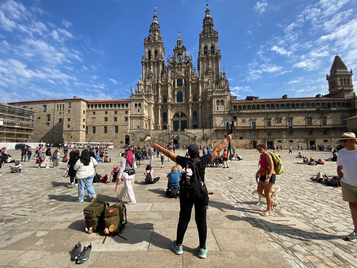 Паломники на площади Обрадойро. и Собор Святого Иакова в галисийском городе Сантьяго-де-Компостела