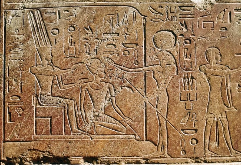 Царица Хатшепсут преклоняет колени перед Амоном-Ра в храме бога в Карнаке.