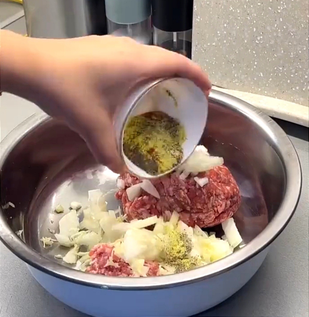 В фарш добавить одну луковицу, чеснок и специи, немного воды для сочности.