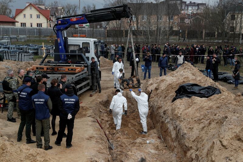    FILE PHOTO: SENSITIVE MATERIAL. THIS IMAGE MAY OFFEND OR DISTURB Forensic technicians exhume the bodies of civilians who Ukrainian officials say were killed during Russia’s invasion and then buried in a mass grave in the town of Bucha, outside Kyiv, Ukraine April 8, 2022. REUTERS/Valentyn Ogirenko