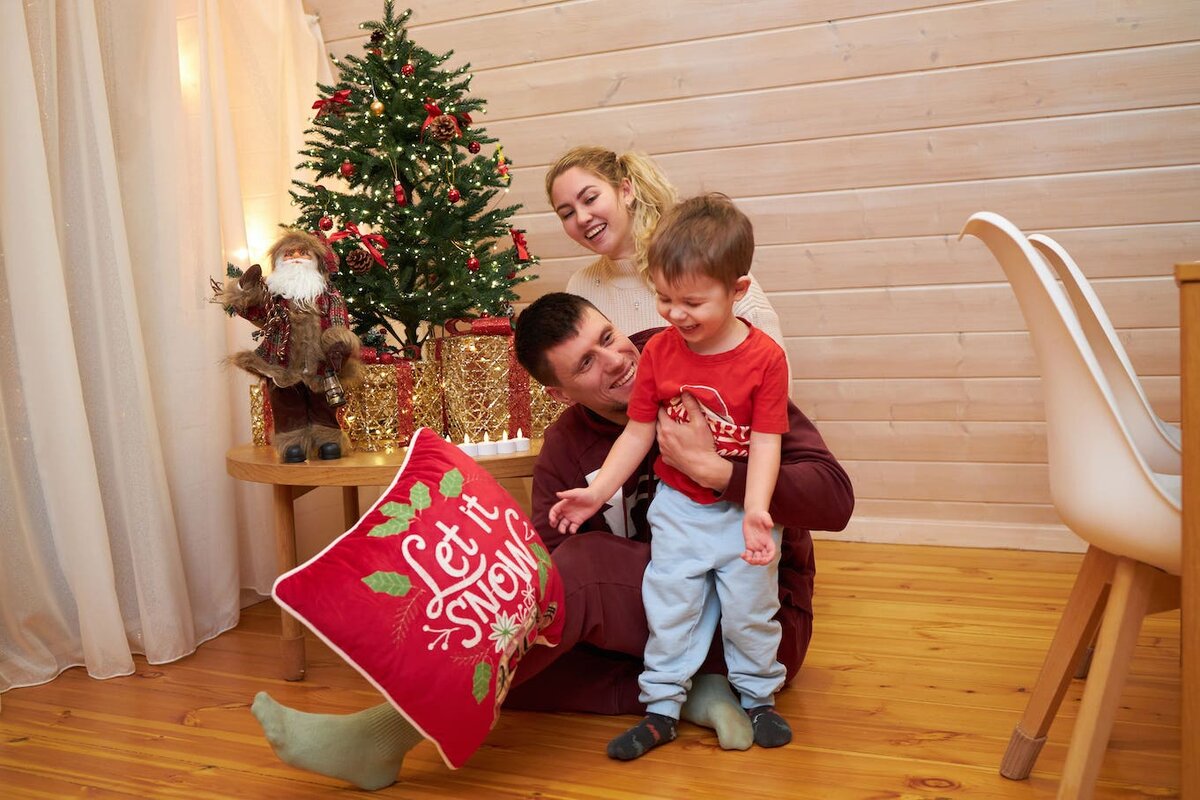 Мама и папа играют с маленьким ребенком на полу теплого домика в Подмосковье