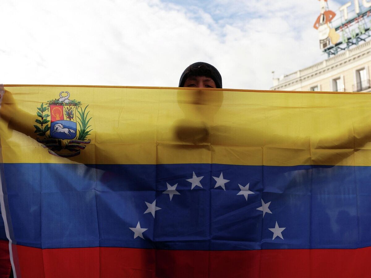   Молодой человек держит флаг Венесуэлы | © REUTERS / Violeta Santos Moura