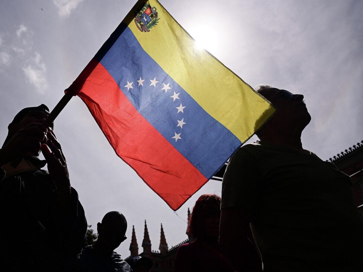    Человек держит флаг Венесуэлы | © REUTERS / Gaby Oraa