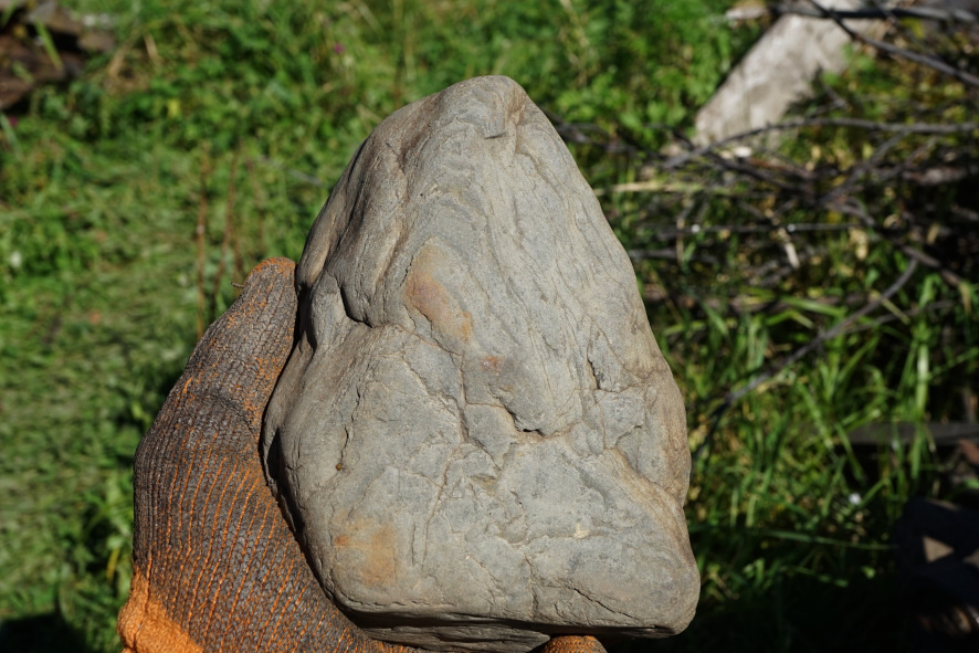 Окатанная каменюка, покрытая множесвом мелких трещин.