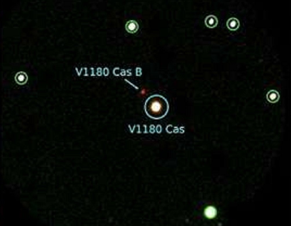    Цветное комбинированное изображение в диапазонах TANSPEC K, H и J, показанные в красном, зеленом и синем цветах соответственно. Голубой кружок показывает местоположение V1180 Cas, в то время как звезды-ориентиры, которые используются для расчета смещений при калибровке инструментальных величин, отмечены зелеными кружками.