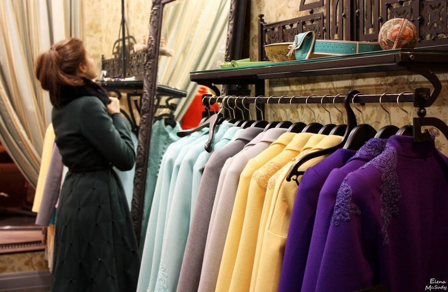 девушка примеряет пальто