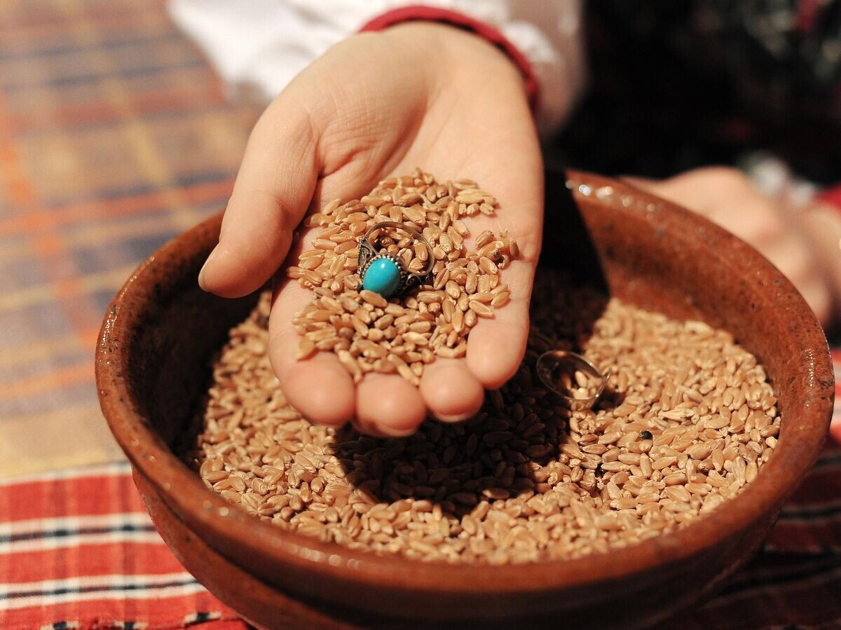    Девушка гадает с кольцом и пшеном во время святок в Челябинске | © РИА Новости / Александр Кондратюк