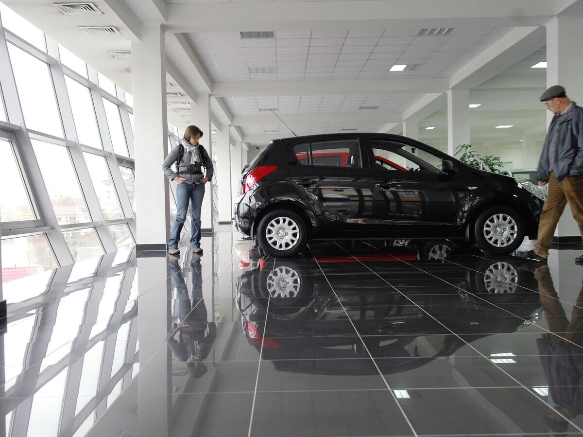    Посетители осматривают автомобиль в автосалоне© РИА Новости . Михаил Мордасов