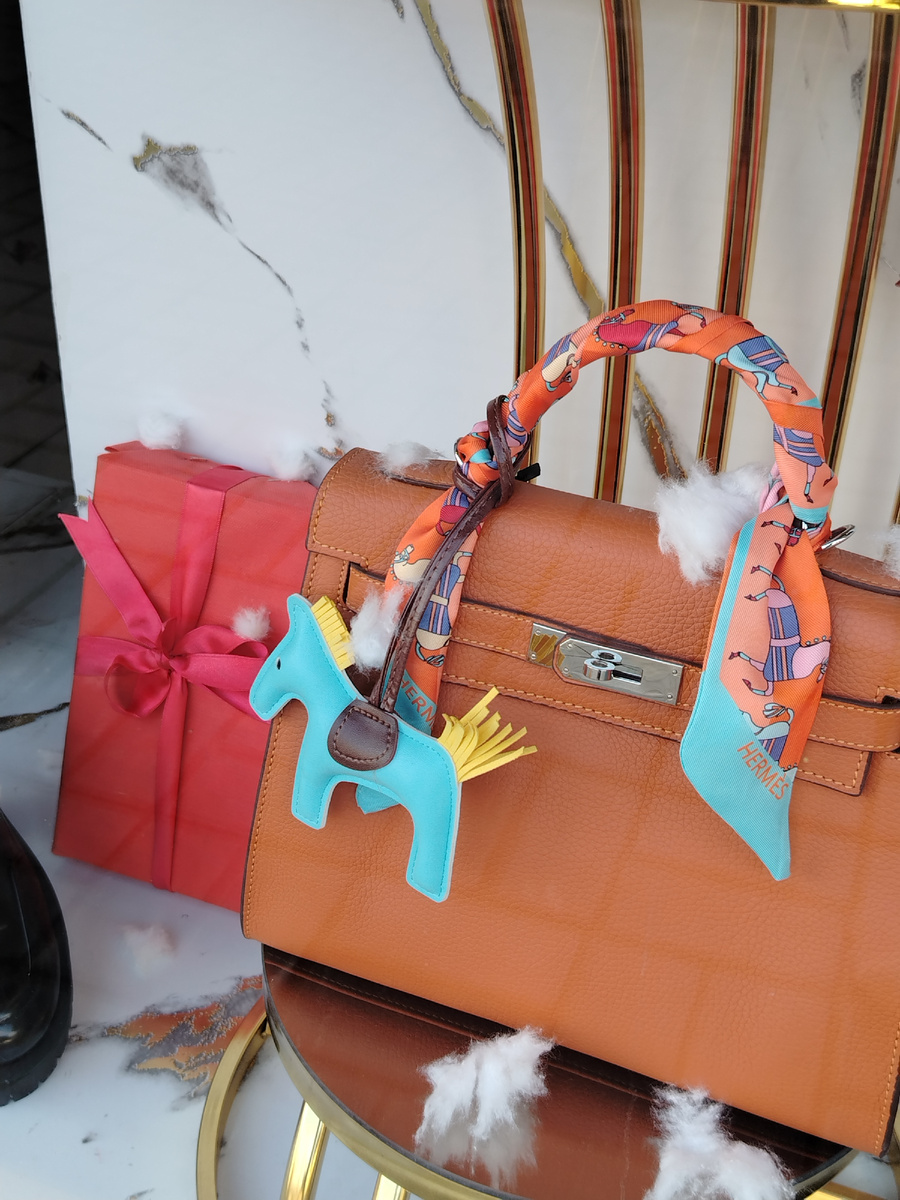 В магазине с кожгалантереей на сумках не только вата, имитирующая хлопья снега, но и брелоки в виде кожаных лошадок. Лошадь - символ 2026 года по восточному календарю. 