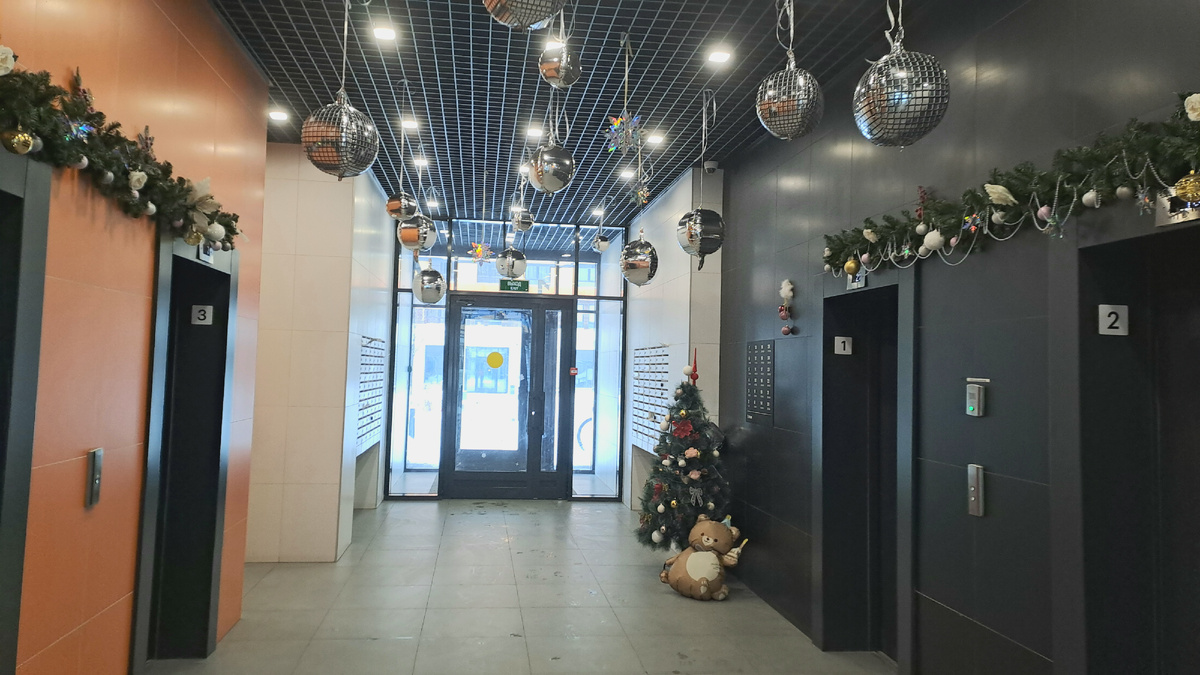 Подъезд на Лётчика Ларюшина. К потолку подвешены надувные шары, имитирующие ёлочные игрушки.