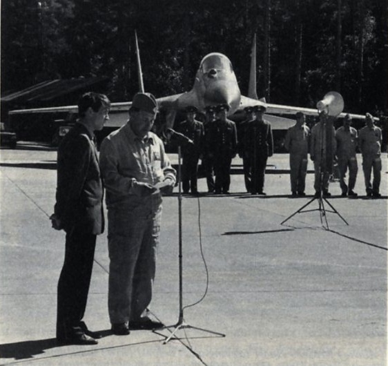 полковник В. В. Лонгиненко, командир отряда истребителей MiG-29, посетившего авиабазу Риссала, отвечает на приветственное слово после прибытия из Кубинки. Обратите внимание на истребитель Fulcrum на заднем плане и, в частности, на большой ИК-датчик поиска и сопровождения целей, расположенный перед кабиной пилота и смещенный вправо. Снимок Кари Стенмана (Kari Stenman) и Эсы Муикку