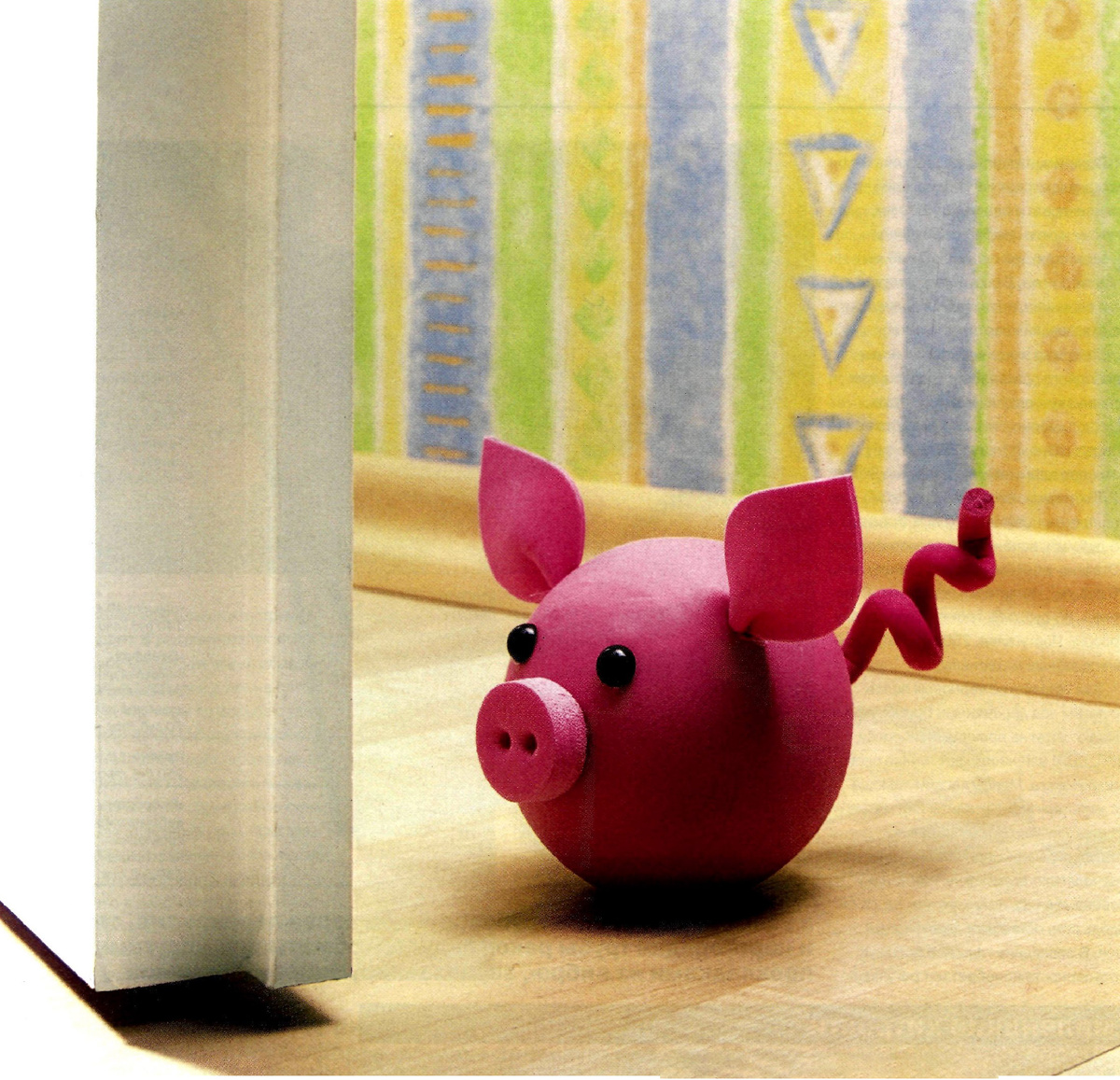 Напольный ограничитель для двери в виде стойкого деревянного поросёнка.