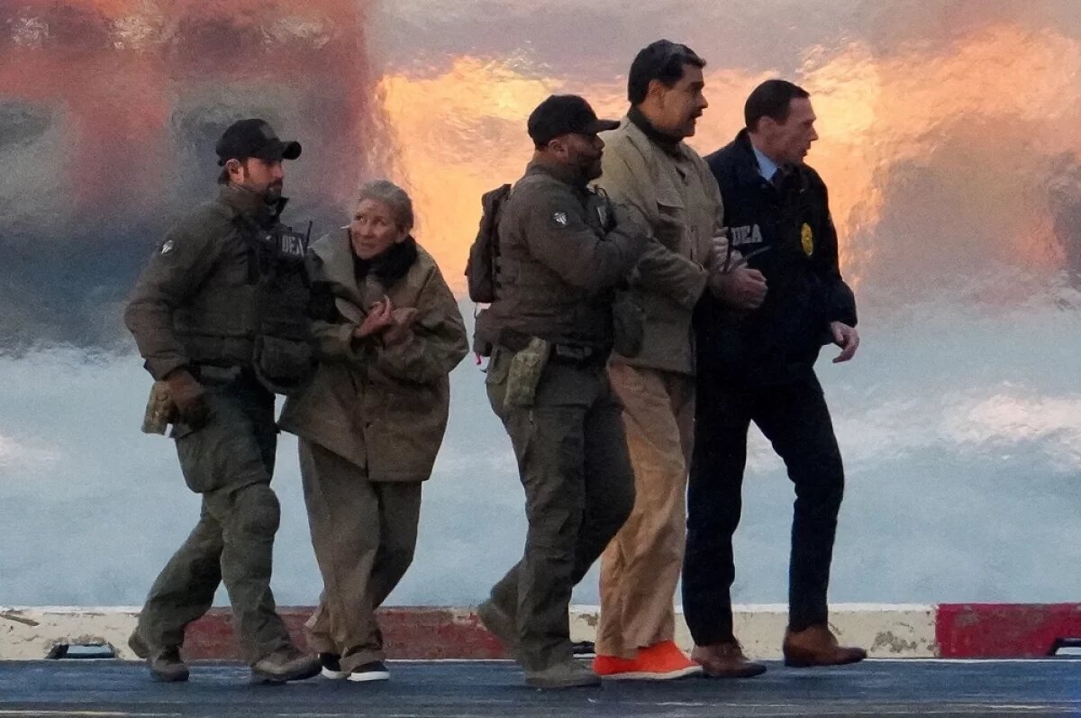    Сотрудники правоохранительных органов доставляют президента Венесуэлы Николаса Мадуро и его жену Силию Флорес из вертолета в здание федерального суда.