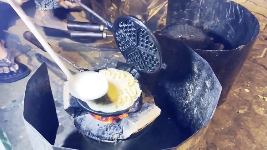 Печёт вафли на углях