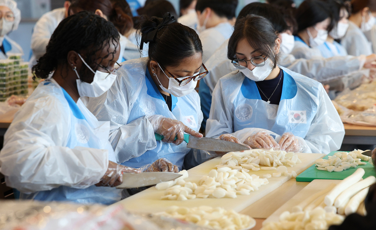 Иностранные студенты готовят ттокгук во время мероприятия в университете Ённам в провинции Северный Кёнсан в понедельник (Ренхап)