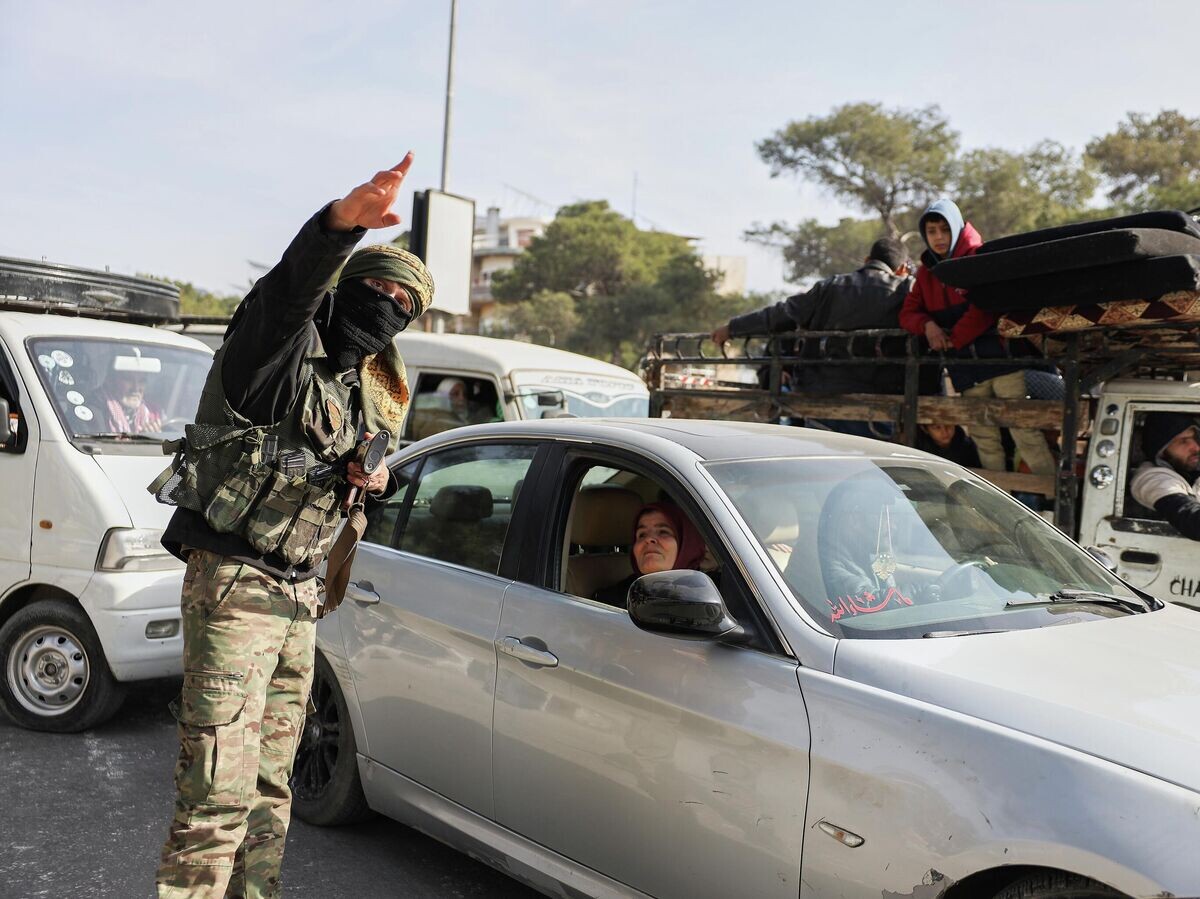    Сирийский военный направляет жителей, бегущих из районов Шейх-Максуд и Ашрафия после боестолкновений с курдами в Алеппо | © AP Photo / Omar Albam
