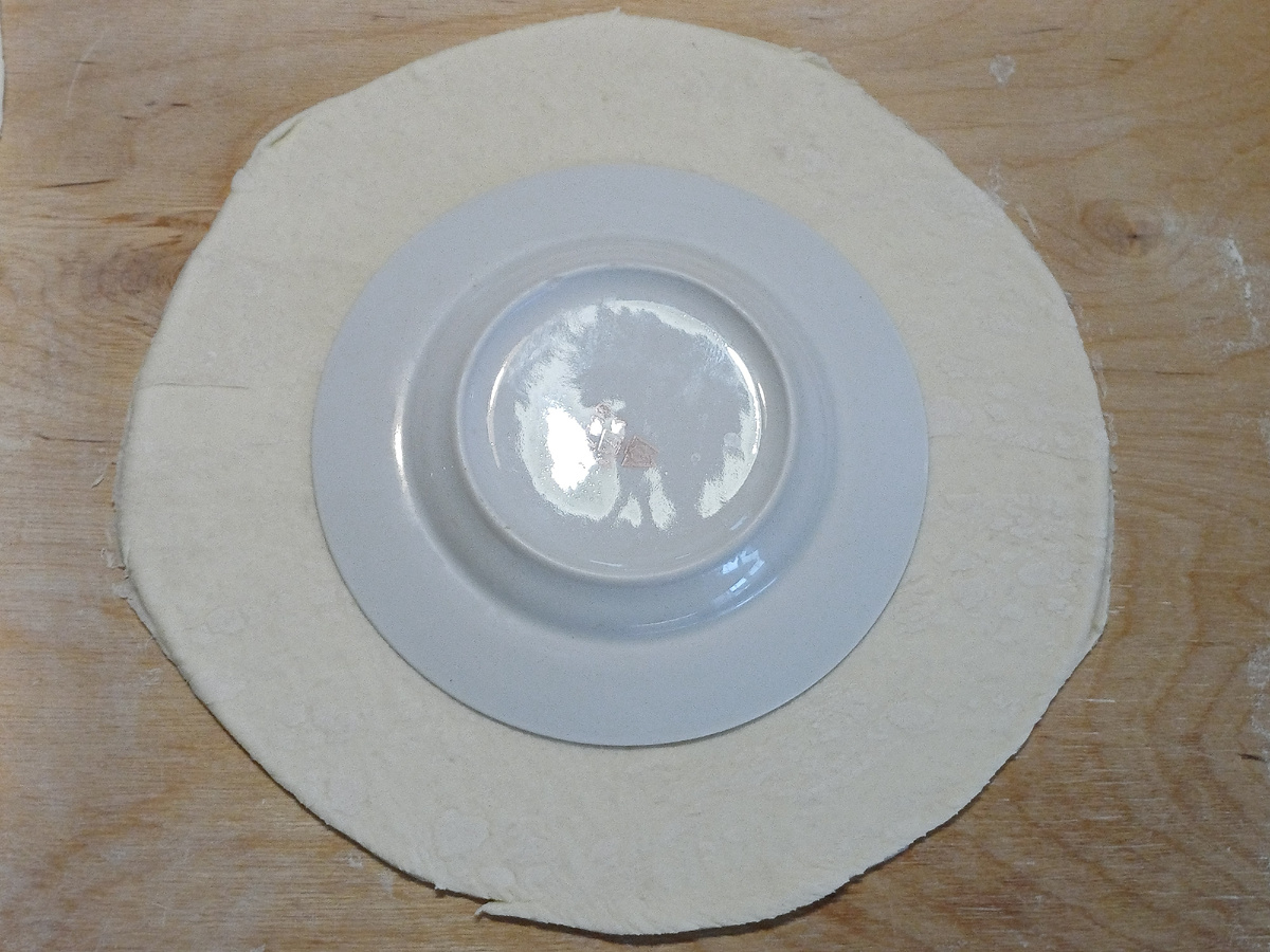 С помощью большого круга от разъёмной формы вырезаю большой круг, а внутри маленький с помощью тарелки по-меньше. Таких нужны 3 заготовки. Полученные маленькие круги тоже выпекаю. Я их потом разломаю на мелкие куски и заложу в "лукошко" с вареньем. Фото автора Юлия Солоха.