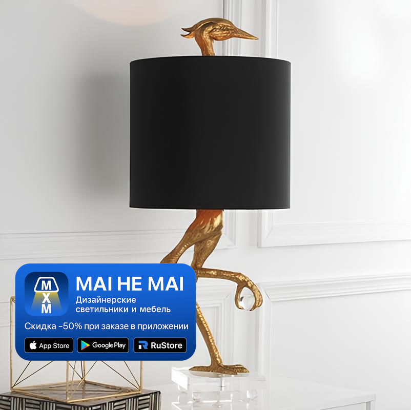 Дизайнерская настольная лампа с фигурной золотой основой и чёрным абажуром в современном светлом интерьере, доступна к покупке в приложении MAI HE MAI.