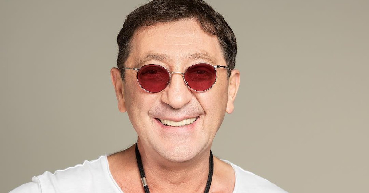 Вчера в Crocus City Hall прошёл концерт, на котором платили по 300 тысяч рублей за столик у сцены. Зал был заполнен не подростками, а состоятельными людьми 40+. На сцене — 61-летний мужчина в чёрном, с хриплым, пробивающим голосом. Григорий Лепс. Уроженец Сочи, исключённый из музыкального училища, судимый за контрабанду валюты в 90-е, а сегодня — владелец собственного лейбла, продюсер, ресторатор и самый дорогой артист на корпоративах российской элиты. Как человек, чья карьера могла закончиться в тюрьме, сумел не просто вернуться, а стать голосом целого социального слоя — бизнесменов, чиновников, силовиков, для которых его песни стали саундтреком их побед и поражений? Это история не о покаянии, а о перерождении. История о том, как построить карьеру на аудитории, которая «выросла из попсы», и создать музыкальный бренд, который ассоциируется с властью, деньгами и жизненным успехом.