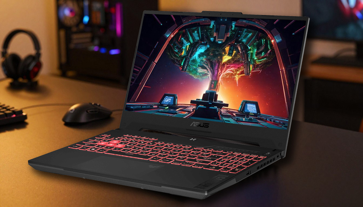 Ноутбук ASUS TUF Gaming A15 занимает центральное место на переднем плане, демонстрируя свой угловатый дизайн и RGB-подсветку клавиатуры. На заднем плане изображена комната с приглушённым освещением и сдержанным технологичным декором, создающим уютную, но энергичную атмосферу. Сцена освещена тёплым рассеянным светом, который подчёркивает металлическую отделку ноутбука, а малая глубина резкости акцентирует внимание на устройстве.