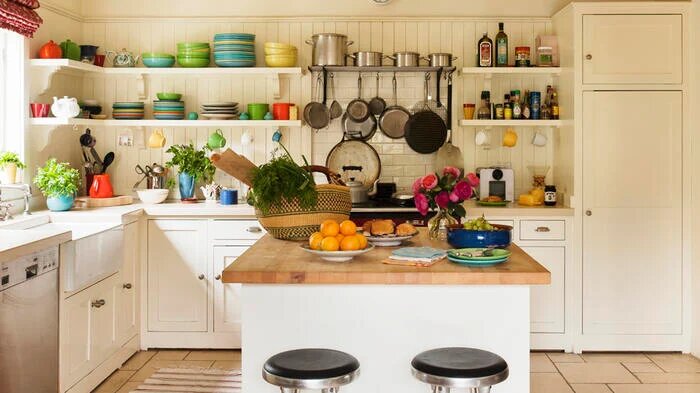 На кухне, оформленной в классическом белом стиле, красочная посуда создает необходимые акценты.