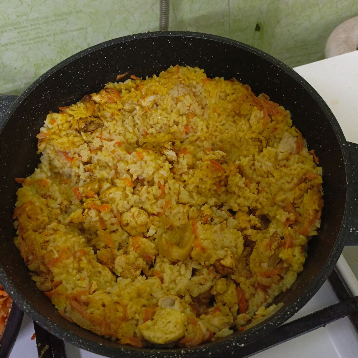 Лук, морковь измельчила, обжарила. Куриное мясо нарезала кубиками, добавила к зажарке, немного обжарила. Добавила рис, специи для плова, соль, перец и зубчики чеснока. Залила водой. Варила 20 минут — ужин готов.