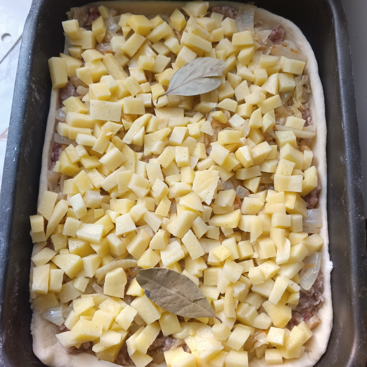 Фарш, капуста с луком, картофель -такая последовательность. Сверху пара лаврушек.