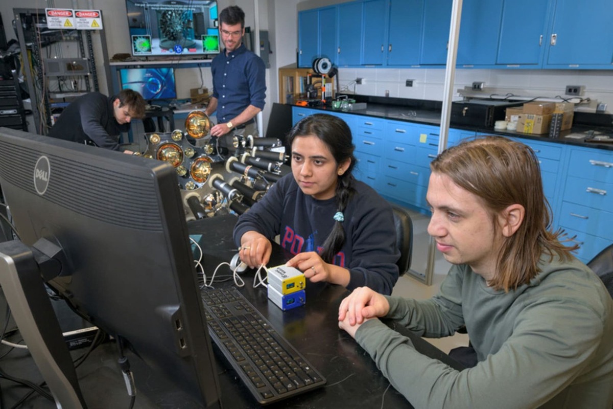    Аспиранты Делавэрского университета изучают данные с устройства CosmicWatch в лаборатории