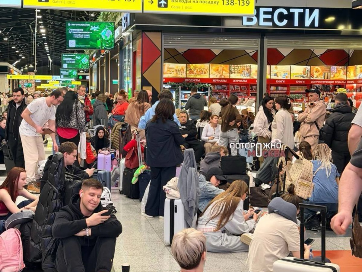   Пассажиры разместились на скамьях и полу, ожидая свой багаж в Шереметьево