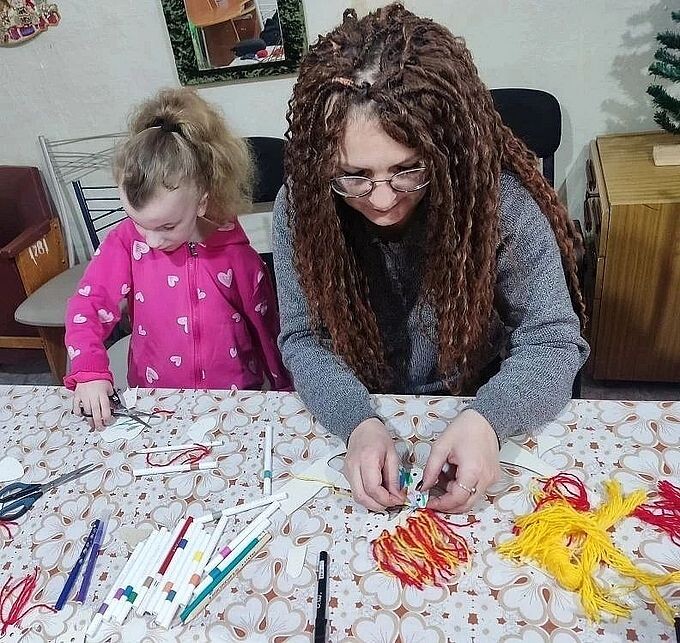 Мама помогает дочери приклеить гриву лошади