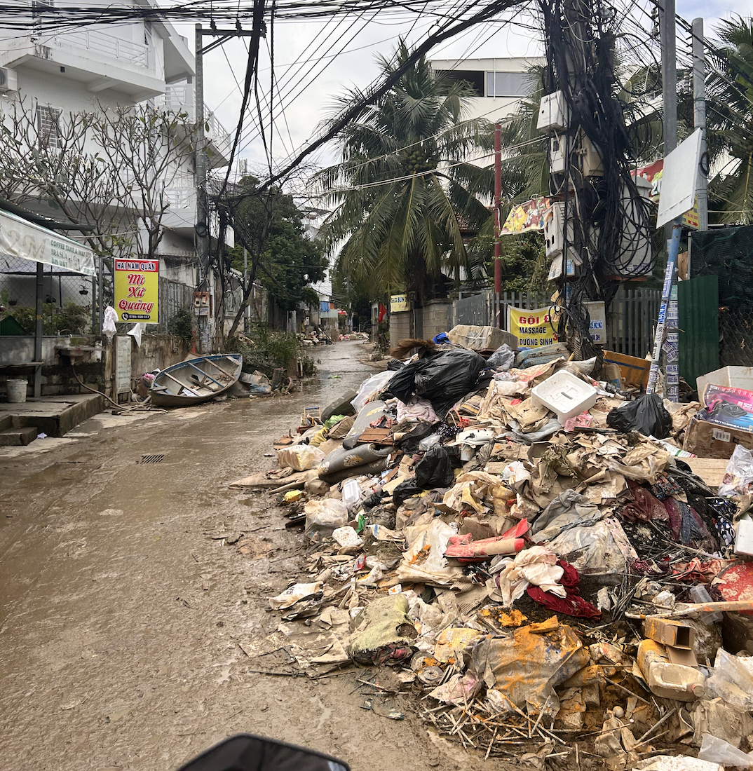 Так выглядели дворы и переулки западной части Нячанга через неделю после разгула стихии. Возле каждого дома лежали кучи сырой и грязной одежды, напитавшие воду мягкие игрушки, разбухшая мебель, матрасы и подушки в песке, затопленная бытовая техника.