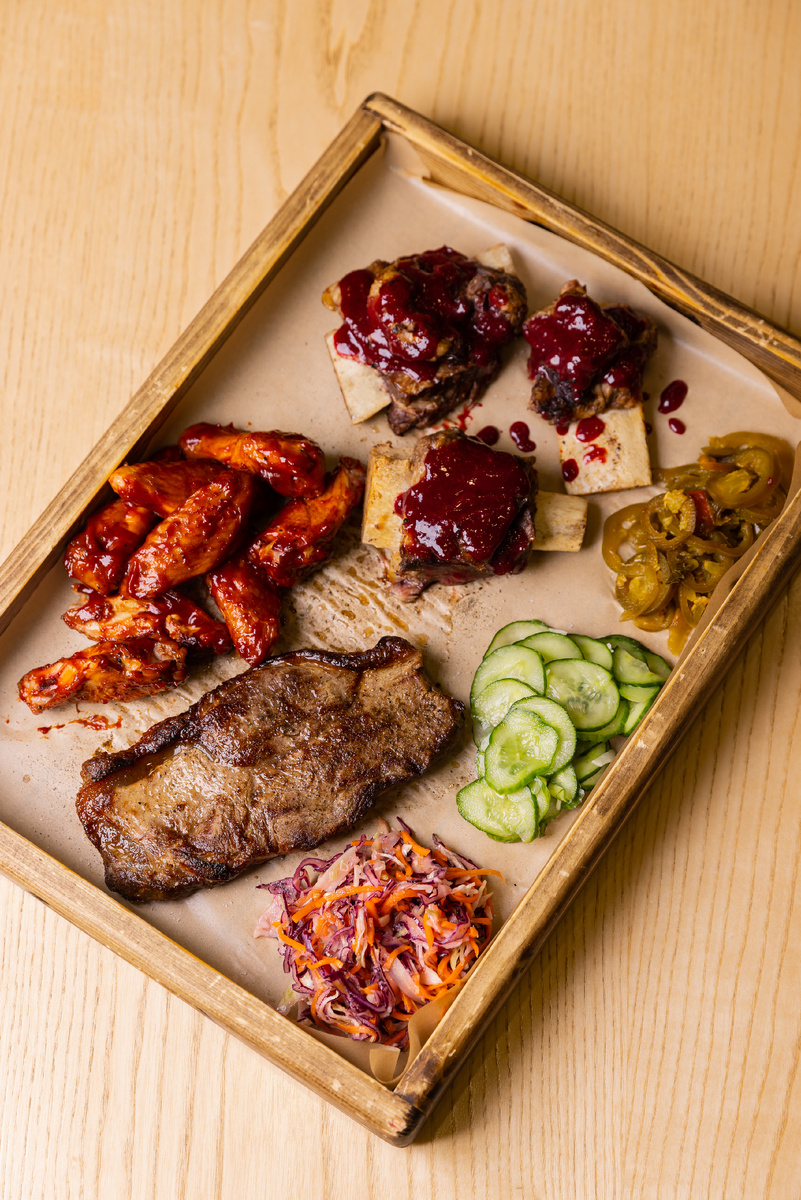 В меню настоящий пир для мясоеда: рёбра, ароматные копчёные колбаски, хрустящие куриные крылышки, стейки, сочные бургеры из мраморной говядины и тягучие сырные кесадильи