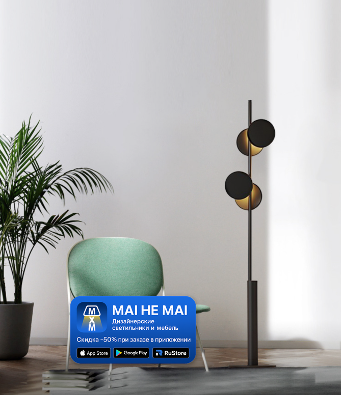 Черный напольный торшер с круглыми плафонами рядом с креслом в светлом современном интерьере с минималистичной обстановкой