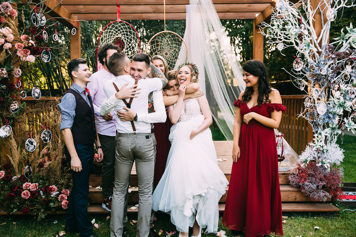 Молодожёны стоят под свадебной аркой в коттеджном посёлке Подмосковья