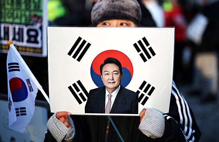    Участник митинга с портретом Юн Сок Еля у здания суда в Сеуле. REUTERS/Kim Hong-Ji