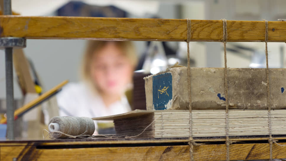 Сшивка отреставрированных тетрадей книги.📷Фото: Евгений Гурко / Коммерсантъ