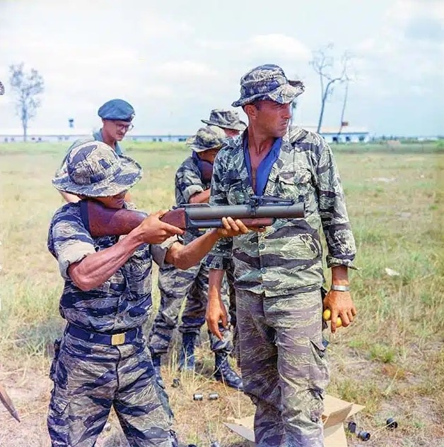 1967 год. Сержант Сил специального назначения армии США проводит инструкцию курсанта Вьетнамской группы гражданской обороны (CIDG) по использованию гранатомета M79. В левой руке сержанта несколько 40-мм осколочно-фугасных гранат.