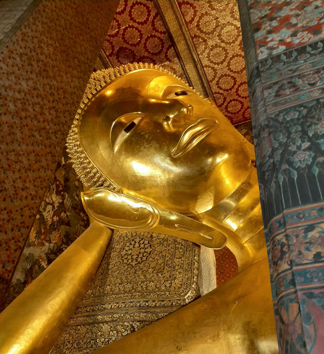 Мочки ушей удлиненные,как знак благородного происхождения и факт ношения длинных тяжелых украшений, а выпуклость на макушке (ушниша)  - символ достигнутого просветления.