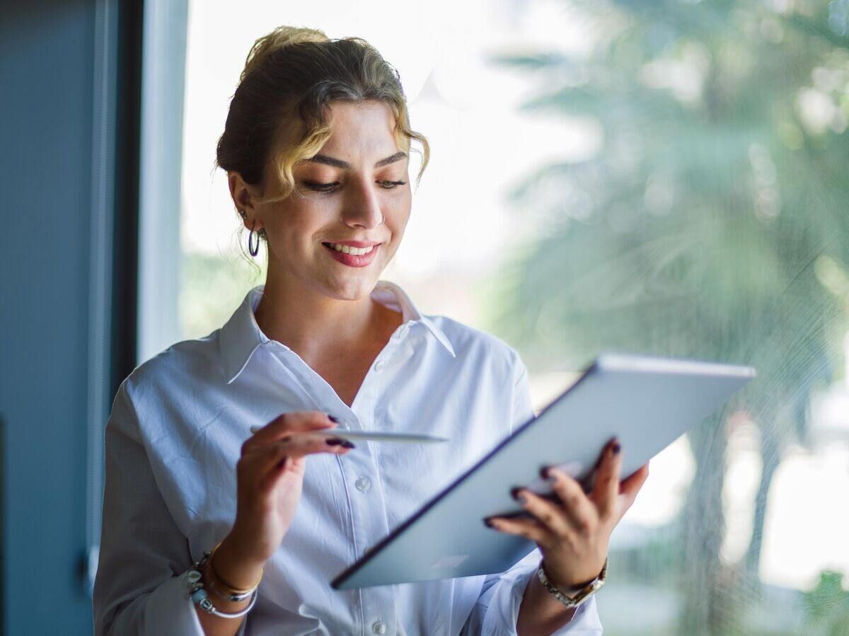    Девушка-предприниматель подписывает электронные документы | © iStock.com / ilkercelik