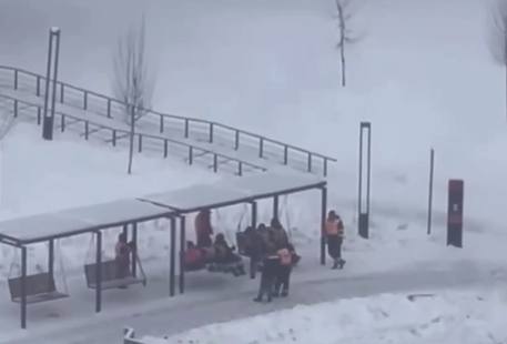 Мигранты-дворники катаются на качелях. Фото: скрин видео очевидцев.