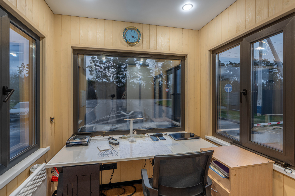 Стильная фотография современного КПП из контейнера: большие панорамные окна, светодиодная подсветка, на фасаде логотип компании. Никакой ржавчины и уныния.