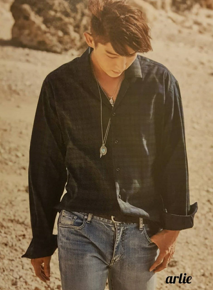 На Джуне потёртые джинсы, тёмная рубашка, простые кеды. Одежда не говорит “смотри на меня”, она скорее говорит “оставь меня в покое”. И именно поэтому взгляд цепляется.