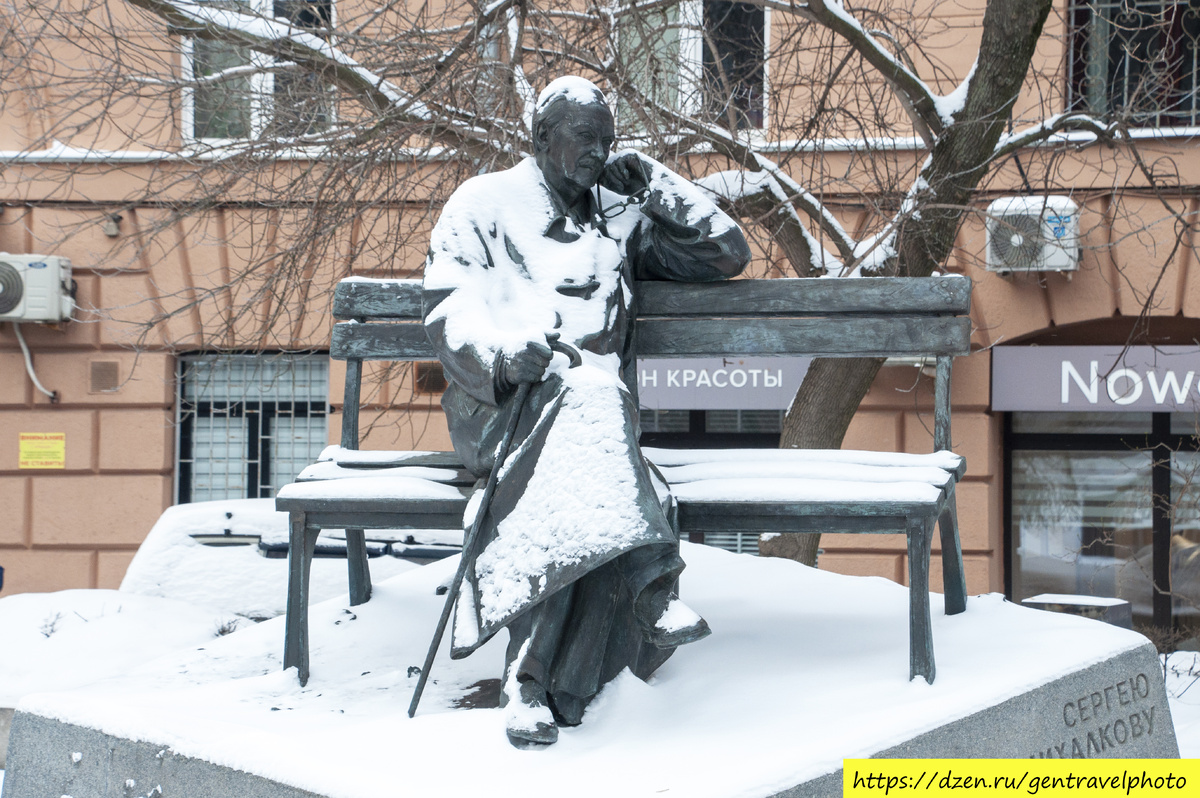 Пожилой писатель сидит на лавочке у своего дома.