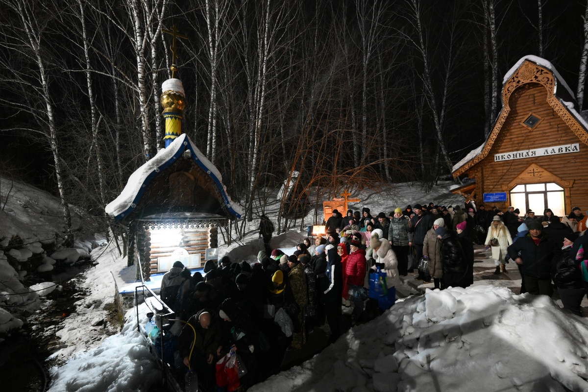     Верующие набирают святую воду в Крещенский сочельник на источнике "Святой ключ" в Искитимском районе Новосибирской области. / РИА Новости / Александр Кряжев