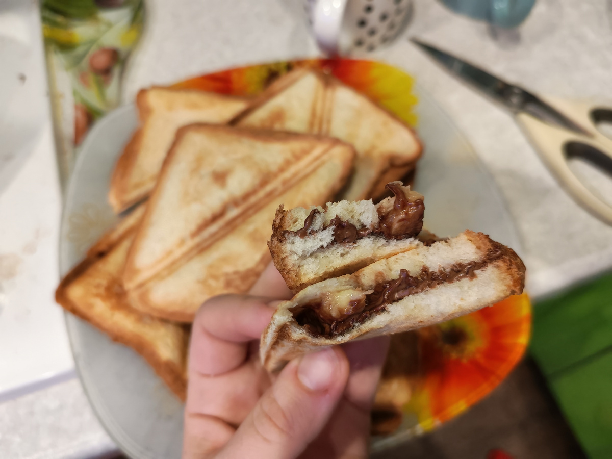 Тостовый хлеб, долька шоколада молочного, кружок банана и на панелях для сендвичей в мультипекаре запечь